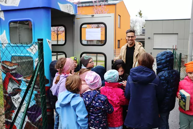 Zum Befüllen der Bücherbox hielt Bgm. Alexander Ernst den Kinder die Telefonzellentür auf.  | Foto: Edith Ertl