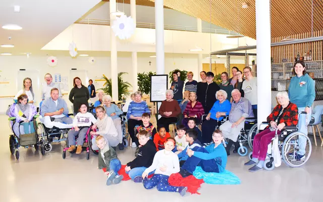 Im Vordergrund FSJ Sarah Pojmann mit Bewohnerin Hermine Scherb, im Hintergrund die
Schülerinnen und Schüler der VS Korneuburg beim Besuch im PBZ Korneuburg.  | Foto: PBZ Korneuburg