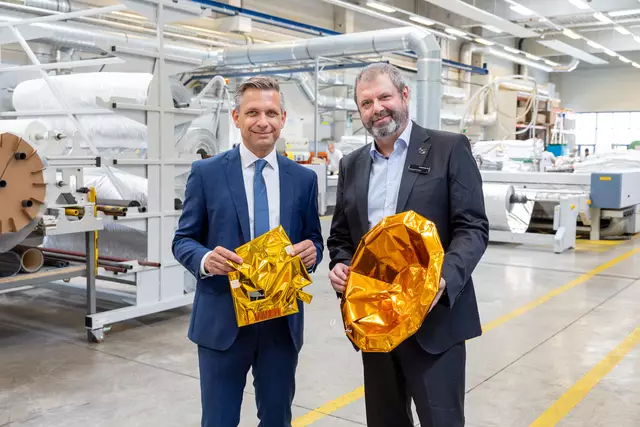Thermalschutz für Satelliten: Wirtschaftsminister Wolfgang Hattmannsdorfer und Wolfgang Pawlinetz, Geschäftsführer Beyond Gravity Austria mit goldenfarbener Thermalisolation für Satelliten bei Beyond Gravity in Berndorf. | Foto: Anna Rauchenberger, Beyond Gravity