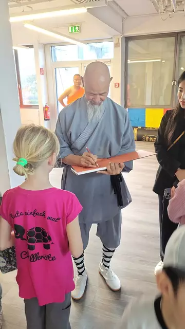 Der Altmeister beim Unterschreiben der Bücher für die jüngsten Fans. | Foto: Andrea Stelzer