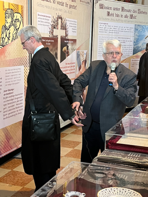 Franz Seiser, Kurator der Ausstellung, demonstriert anhand eines "Freiwilligen" die Foltermethoden um weitere Namen von den gefangenen Täufern herauszupressen. Diese wurden an der an beiden Handgelenken befestigten Metallfessel rücklings an einem Seil aufgehängt und gereckt. Ein sehr schmerzhaftes Unterfangen. | Foto: Verena Schnitzhofer