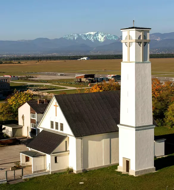 Kirche der Flugfelder Pfarrgemeimnde St.Anton mit dem Militärflugplatz und dem Schneeberg im Hintegrund.