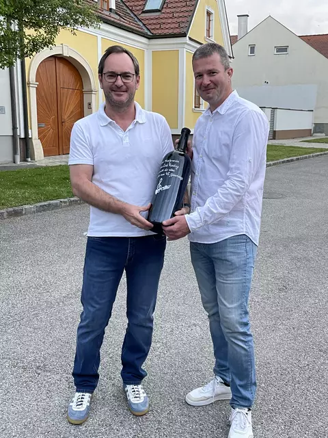 Bürgermeister und Vereinsobmann Markus Landauer überreichte dem langjährigen Kapellmeister eine überdimensionale Weinflasche als Zeichen der Anerkennung und des Dankes für dessen herausragendes Engagement. | Foto: Markus Landauer