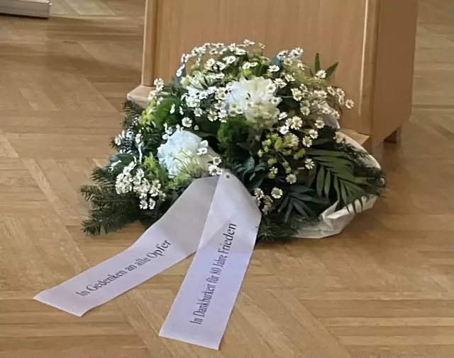 Der Kranz vor dem Rednerpult sollte ursprünglich an der Brücke der Begegnungen im Schlosspark liegen, wetterbedingt fand die Gedenkfeier aber im Rathausfoyer statt.