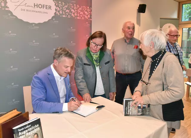 Tarek Leitner beim Signieren seines Werkes „Augenblicke der Republik“. | Foto: Herbert Schleich