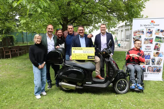 Holger Perzl, einer der Organisatoren des Vespatreffens, überreicht den Scheck an die Tagesstätte St. Martin. Mit dabei Vespatreffen-Moderator Philipp JelinJelinek (4. v. links) und Bürgermeister Christoph Kaufmann (ÖVP, 2. von rechts). | Foto: Stadtgemeinde Klosterneuburg/Lutz