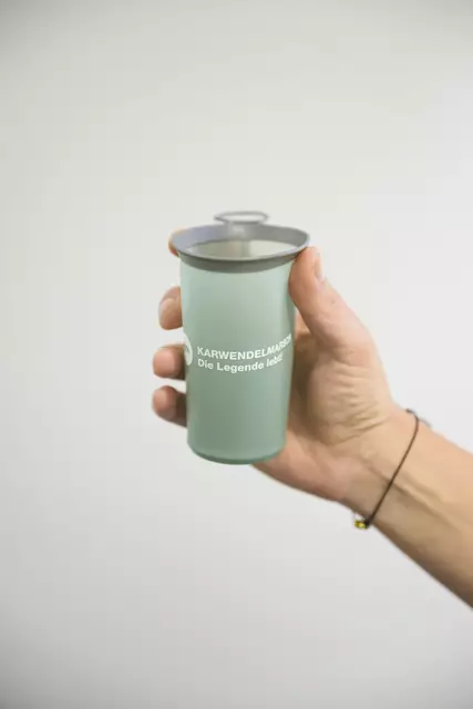 Ein nachhaltiger Faltbecher wurde im Zuge des Pressetermins vorgestellt, der künftig zur weiteren Müllreduzierung bei der Abhaltung des Karwendelmarschs beitragen wird. | Foto: Karwendelmarsch / Oss