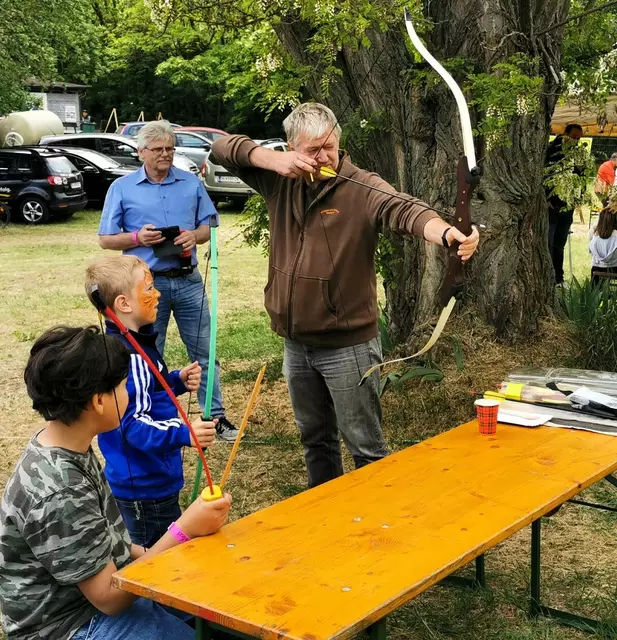 Bogenschütze Helmut Wenzina zeigt es Kindern vor. | Foto: Josef Messirek