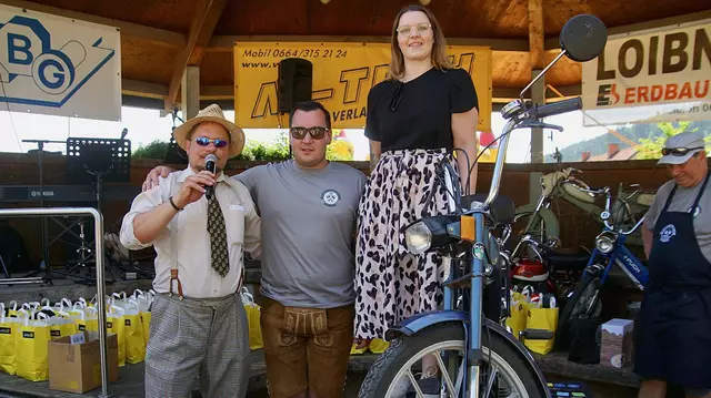 Sprecher Gerald Feldbaumer und Obmann Martin Reiter von den Oldtimerfreunden Kobenz  freuen sich mit Pflegeassistentin Melanie Sprung über ihren Hauptgewinn, eine Puch Maxi.