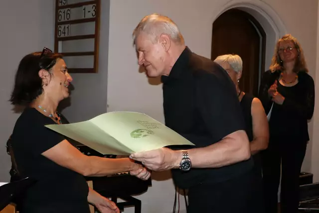 Das Ehrenzeichen des Chorverbandes Steiermark wird von Präsident Dominikus Plaschg an Petra Stelzl überreicht | Foto: Gerhard Langmann