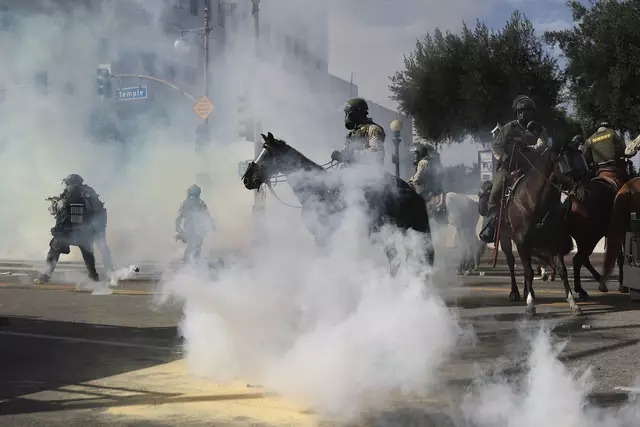 Tränengas umzingelt berittene Polizeibeamte während einer Protestaktion am 14. Juni in Los Angeles. | Foto: Ethan Swope / AP / picturedesk.com