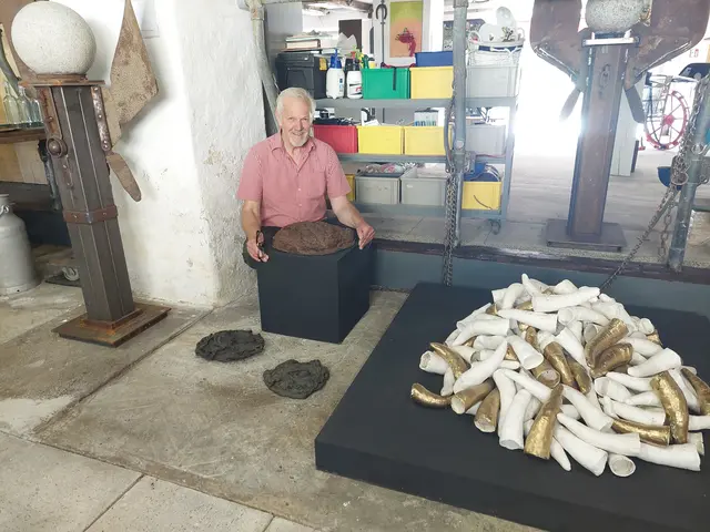 Johann Schreilechner mit seinem Lieblingswerk "Gsund gschißn". Daneben sieht man "Verkaufte Würde" eines seiner polarisierendsten Werke, wie er selbst meint. "Das Horn, die Würde der Kuh wird ihr abgenommen und zum goldenen Füllhorn der EU."