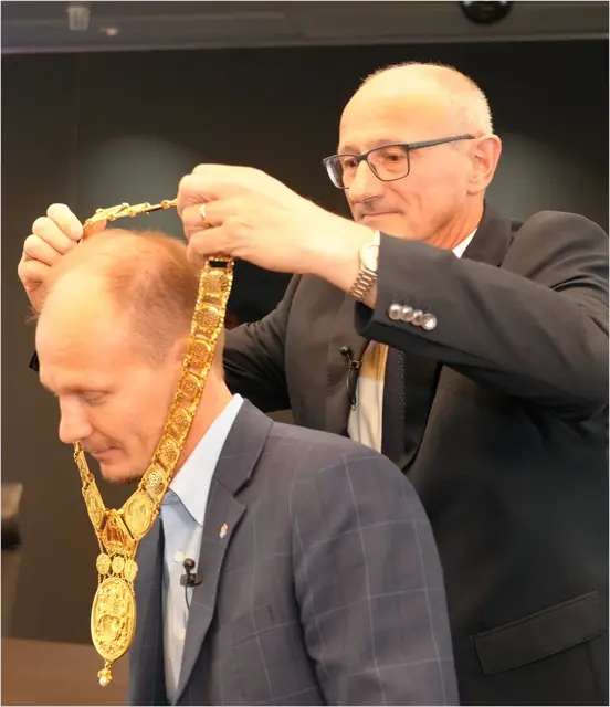 Landeshauptmann Anton Mattle hängt Johannes Anzengruber die Bürgermeisterkette um. | Foto: Erich Staudinger