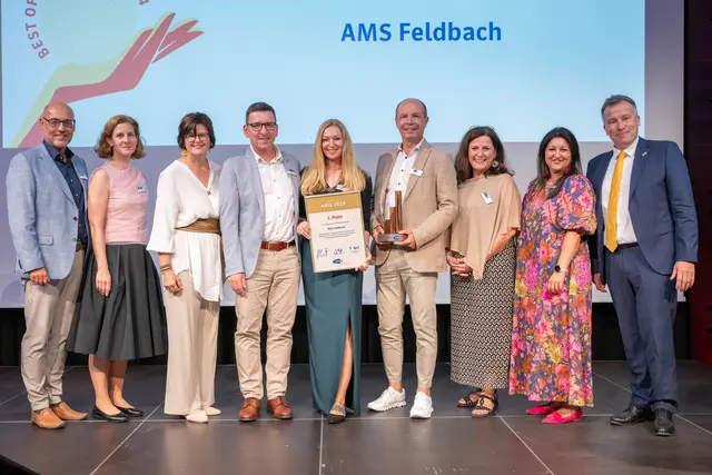 Verleihung in Hallwang: Das Team aus Feldbach unter AMS-Geschäftstellenleiter Edmund Hacker (4. v. r.) – hier mit der Landesgeschäftsführung und den AMS-Vorständen – freut sich über Urkunde und Trophäe. | Foto: AMS 