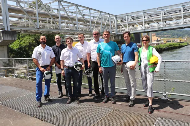 Silvio Santacroce, Oliver Bürger, Wolfgang Fuchs, Christian Wersonik, Robert Niessner, Steffen Wurdinger, Peter Putz und Katharina Neubauer (alle Sappi) beim Festakt auf der Brücke des Werkskanals.   | Foto: Edith Ertl