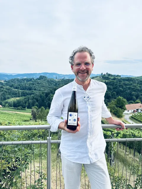 Die perfekte Ergänzung: Wolfgang Maitz mit einer Flasche "Make it matter"-Wein | Foto: BRAND DESIGN STUDIO