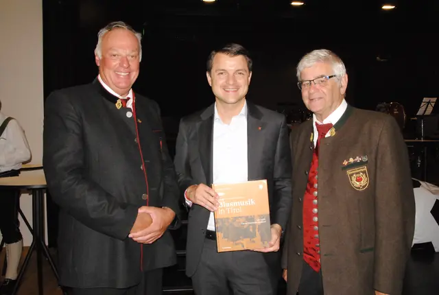 Bezirksobmann Sebastian Neureuter (li) und Obmann-Stellv. des Landesverbands Raimund Winkler (re.) überreichten BH Kurt Berek das Buch „Blasmusik in Tirol“. | Foto: Eberharter