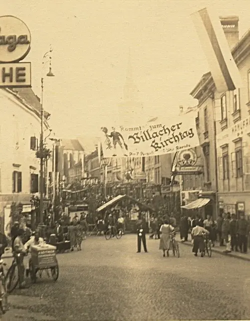 Ein Foto vom unteren Hauptplatz/Ecke Gerbergasse. Aufgehängt ein Plakat mit der Einladung, beim Villacher Kirchtag vorbeizuschauen. | Foto: Archiv Villacher Kirchtag