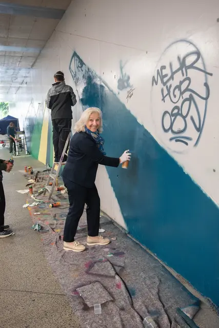 Stadträtin Andrea Brandner machte sich vor Ort ein Bild und probierte das sprayen gleich selbst aus.  | Foto: Stadt Salzburg/Rocio Escabosa