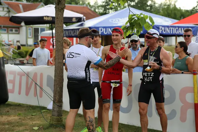 Zwei Athleten die einklatschen nachdem sie den Aquathlon gemeistert haben. | Foto: Flicker, St. Andräer Aquathlon