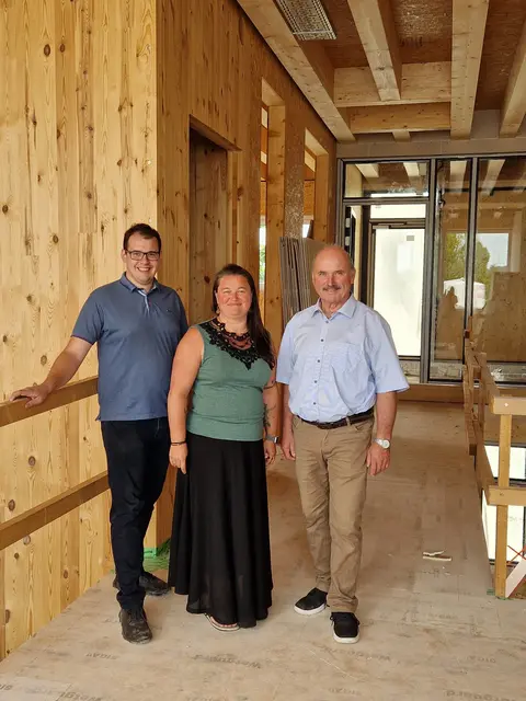 Amtsleiter Michael Reindl, Kindergartenleiterin Sandra Mayr und Bürgermeister Ulrich Flotzinger besichtigen den Rohbau des neuen Kindergarten.