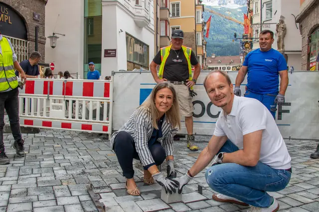 Bürgermeister Johannes Anzengruber und Stadträtin Mariella Lutz setzen gemeinsam den letzten Pflasterstein in der Herzog-Friedrich-Straße und besiegeln damit den Abschluss der Arbeiten in der Innsbrucker Altstadt. | Foto: © M. Freinhofer