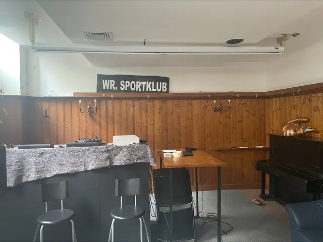 Im Keller des "Annemarie" gibt es regelmäßig Karaokeabende. Hinter der Anlage hängt auf der Holzwand noch die Anzeigetafel des alten Stadions. | Foto: Kristof Paksanszki/MeinBezirk
