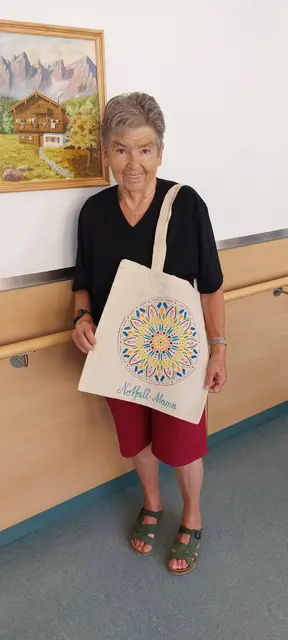 Eine stolze Künstlerin und ihr Werk. Die Aufschrift Notfallmama soll zu Gesprächen über dieses tolle Projekt anregen.  | Foto: Haus Sebastian