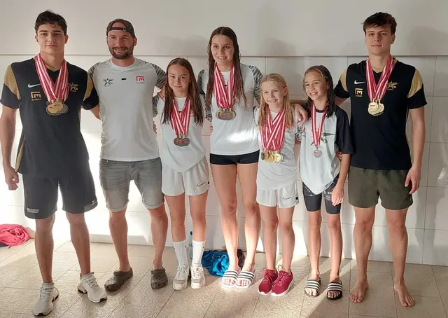 Bei den ASKÖ Bundesmeisterschaften 2022: Trainer Christian Wohlmutter mit den siegreichen Vereinsmitgliedern. Darunter Lilli Paier (3. v. re.) – mit 7x Gold, 1x Silber (50m Schmetterling) und 1x Bronze (50m Rücken). Neben ihr ihre Schwester Linda Paier (Mi.), die bei diesen Bundesmeisterschaften ebenfalls neun Medaillen holte.  | Foto: SV Leoben