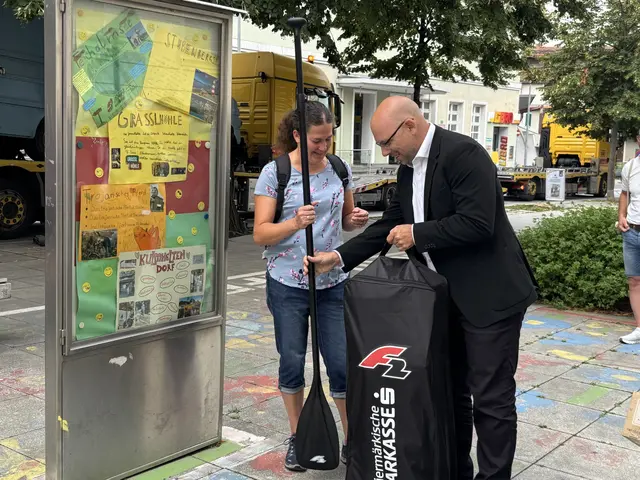 Marco Klammler, Beirat der Einkaufsstadt und Filialleiter der Sparkasse Weiz, übergibt Elisabeth Karner das Stand-up-Paddle | Foto: MeinBezirk
