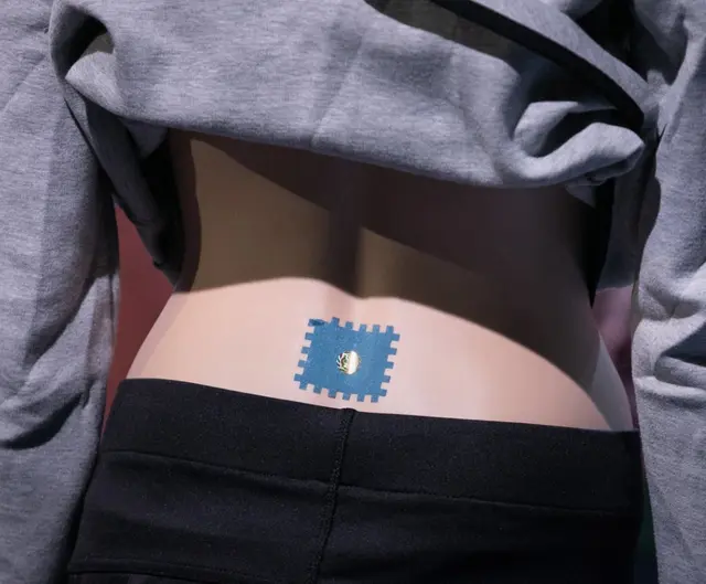 Das Back-Tape wird im Bereich der Lendenwirbelsäule aufgeklebt. | Foto: Puls 4/Gerry Frank