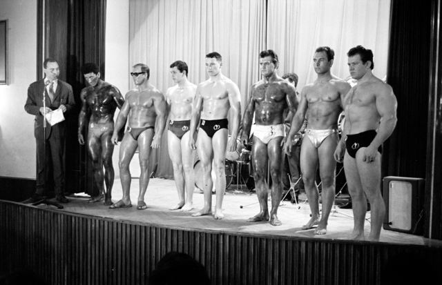 Arnold Schwarzenegger (Mitte) und weitere Bodybuilder auf einer Bühne im Hotel Steirerhof im Juni 1964. | Foto: Stefan Amsüss, MMS/UMJ