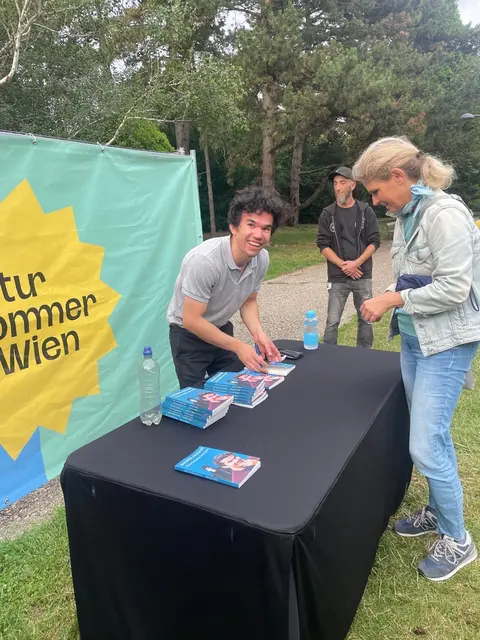 Ahmadi signiert seine Biografie am Kultursommer Wien.  | Foto: Nina Horaczek