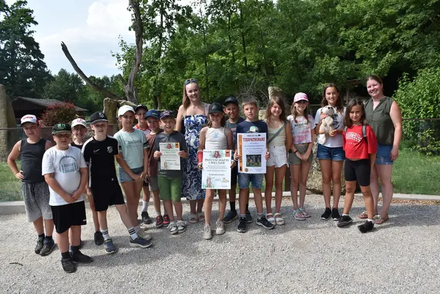 Die Erdmännchenklasse der Volksschule Schiedlberg mit Klassenlehrerin Sarah Zielger und der zoologischen Leiterin Barbara Forstner mit Präsentation der Tierpatronanzurkunde und derJahrespatenschaftsurkunde. | Foto: Herbert Stoschek
