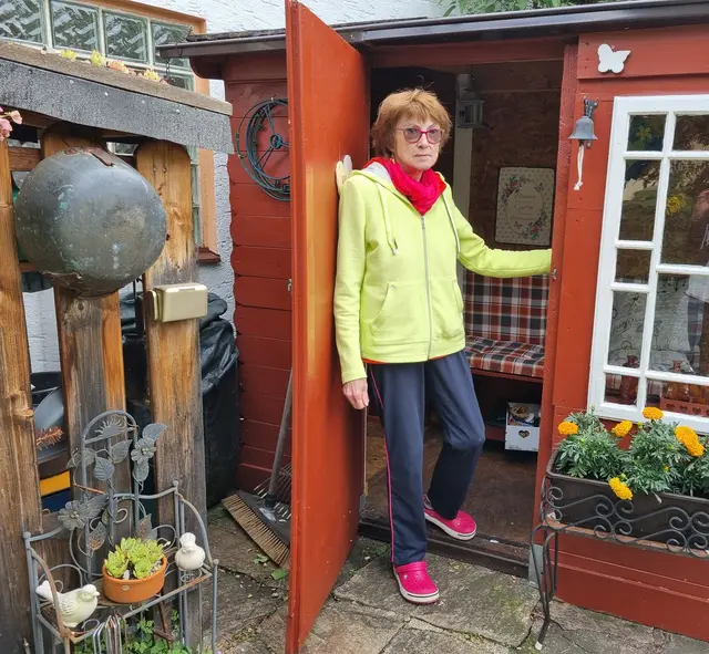 Gisela Löw in ihrem "Schwedenhäuschen", das mit gemütlicher Bank auch bei Regenwetter zum Verweilen einlädt.  | Foto: Astrid Höbenreich-Mitteregger