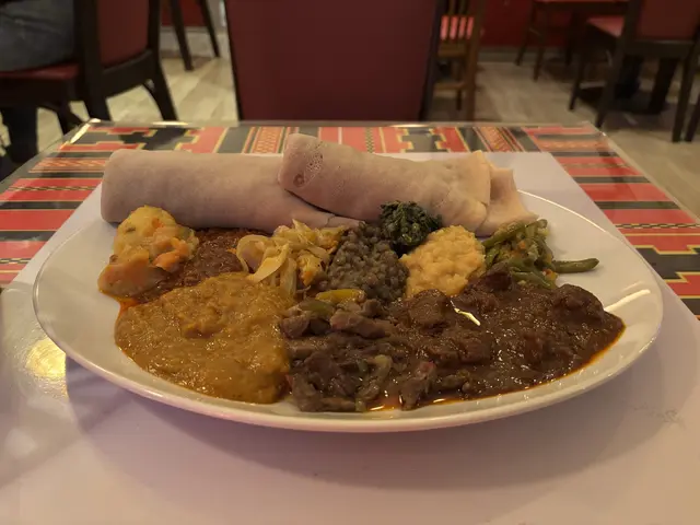 Besteck sucht man auf den Tischen vergeblich. Dafür dient das Injera, das zusammen mit den Hauptspeisen in die Hände genommen wird. | Foto: Matthias Pandrea