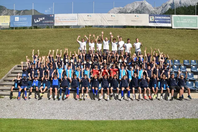 80 strahlende Nachwuchskicker werfen auf Kommando die Hände in die Luft, ein fröhlicher Höhepunkt des SC Mils 05 Fußball-Camps.