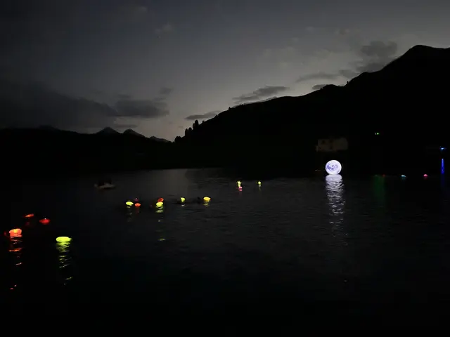 Ein idyllischer Anblick: Die bunten Leuchtbojen der Schwimmer spiegeln sich im nachtschwarzen See. | Foto: Nicole Hettegger