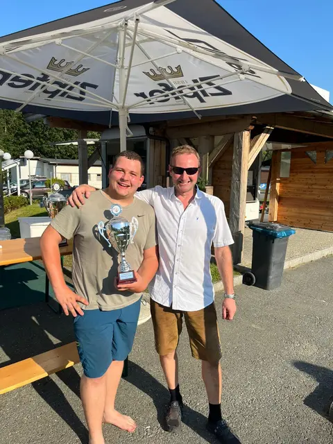 Kevin Hiebaum (links) holt sich den Titel „Hogmoar 2025" im Boahaggln. Den Pokal überreicht Veranstalter Benjamin Schmid.
 | Foto: Kegelbahn Reith