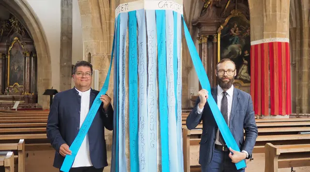 Pfarrassistent Roland Altreiter (l.) mit dem Obmann des Pfarrgemeinderates, Simon Voggeneder (r.), vor den beschrifteten Säulen in der Pfarrkirche Freistadt. | Foto: Pfarre Freistadt