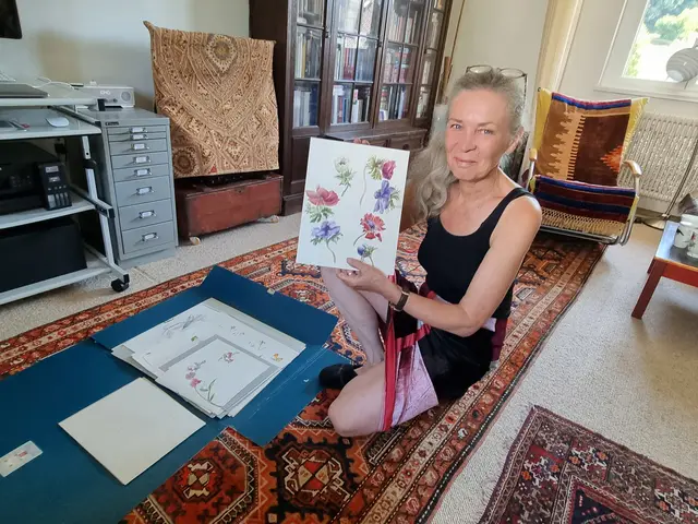 Heike Trobisch öffnet die Mappe, in der ihre Blumenstudien aufbewahrt werden. Es sind kunstvolle Aquarelle.   | Foto: Astrid Höbenreich-Mitteregger