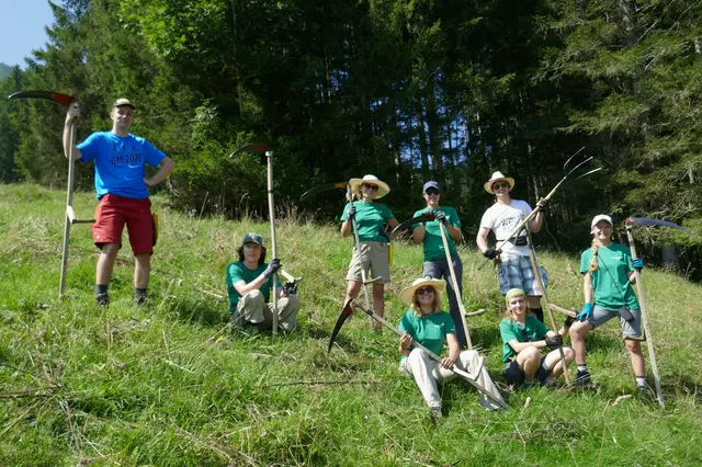 Ein Teil der Freiwilligen mit Sensen, die zum „Schwenden“ verwendet werden.
 | Foto: ÖAV/Umweltbaustelle "Bergwiesn heign"