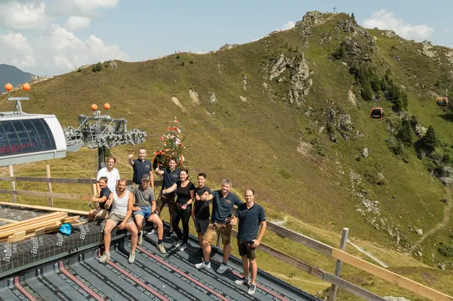 Firstfeier auf der Schlossalm, u. a. mit Markus Papai (Leitung Marketing und Sales GBB, sitzend links), Sebastian Kroesen (Architekt, stehend links), Andreas Innerhofer (Vorstand GBB, stehend 2. v. l.), Benjamin Rogl (Vorstand GBB, stehend 3. v. l.), Birgit Maier (Geschäftsführerin Holzbau Maier, stehend 4. v. r.), Christian Hochreiter (Betriebsleiter und Prokurist GBB, stehend 2. v. r.), Peter Neufang (Technik Büro GBB, stehend rechts). | Foto: Gasteiner Bergbahnen AG/Fotoatelier Wolkersdorfer