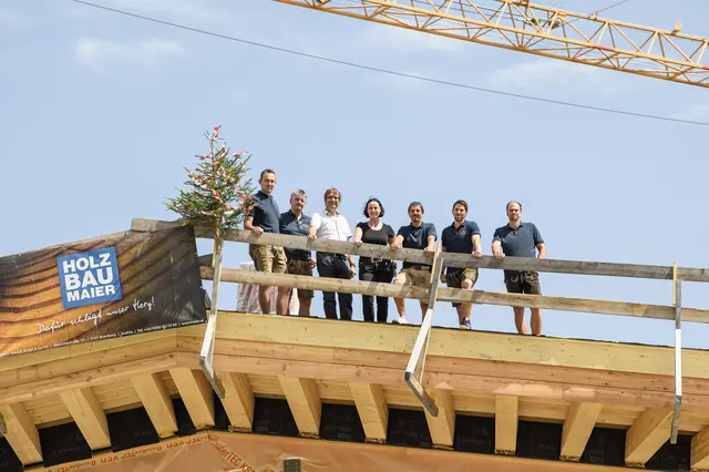 Bei einer Firstfeier wird traditionell ein Baum am Dachfirst befestigt, der Glück und Schutz bringen soll. Von links: Andreas Innerhofer, Christian Hochreiter, Sebastian Kroesen, Birgit Maier, Markus Papai, Benjamin Rogl und Peter Neufang. | Foto: Gasteiner Bergbahnen AG/Fotoatelier Wolkersdorfer