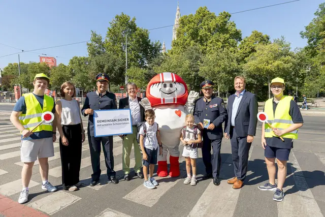 Klaus Robatsch, Leiter des Bereichs Verkehrssicherheit im KFV; Bundespolizeidirektor Michael Takács, Roland Pichler, Generaldirektor-Stv. der AUVA; mit Sicherheitsmaskottchen Helmi, zwei Schülerlotsen und Schulkindern  | Foto: KFV / APA Fotoservice / Krisztian Juhasz