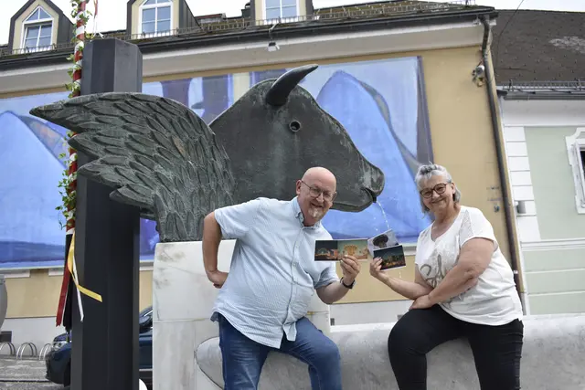 Fotograf Helmut "PhotoHeli" Kutej und Gerhild Toplitsch, Naturkosmetik-Expertin sowie Visagistin und Make-up-Artist in Ausbildung, beim Bleiburger Freyungsbrunnen mit den ersten vier Wiesenmarkt-Postkarten | Foto: MeinBezirk.at