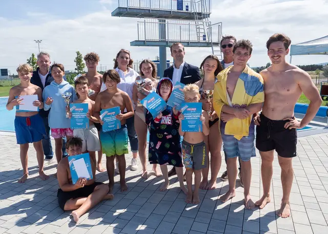 Die Jury bestehend aus Aqua Nova-Leiter Markus Kopecky, Gemeinderätin Barbara Dunst (SPÖ), Jugendstadtrat Kevin Pfann (FPÖ) und Gemeinderat Franz Hatvan (ÖVP) mit den vier Siegerinnen und Siegern Nikolas, Fabian, Joelle und Ines sowie einigen Teilnehmern des Sprungwettbewerbs. | Foto: Stadt Wiener Neustadt/Maurer