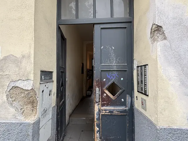 Die Tür in das Gebäude am Reumannplatz 2 ist zerkratzt, hat ein großes Loch und lässt sich nicht schließen. | Foto: Nathanael Peterlini/MeinBezirk