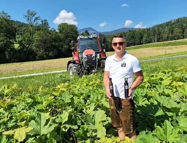 Thomas Wild in seinem Kürbisfeld mit dem aus eigenen Kürbissen produziertem Kürbiskernöl. | Foto: Familie Wild