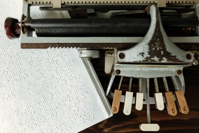 Detailaufnahme einer historischen BrailleSchreibmaschine und Braillepapier als Symbol für die Jubiläumsausstellung „Die Sprache der Punkte – 200 Jahre Brailleschrift“ | Foto: Pexels 